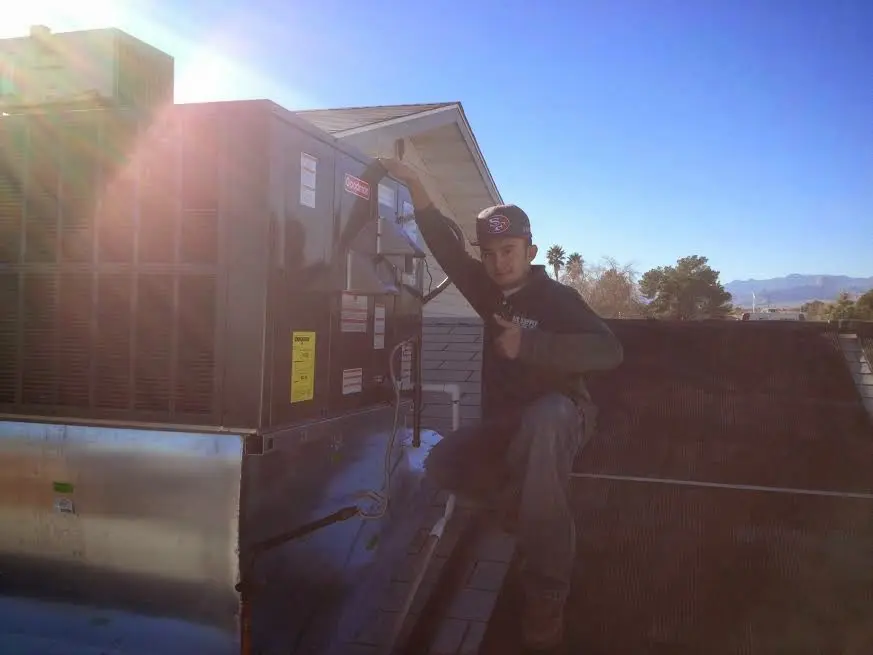 HVAC technician performing Boiler Repair on a rooftop unit in Hilmar-Irwin